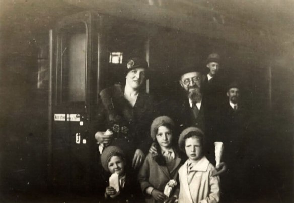 Rabbi Dr. Akiva Posner, his wife Rachel and their three children: from right to left: Avraham Chaim, Tova and Shulamit, at the train station in Kiel upon leaving Germany, 1933